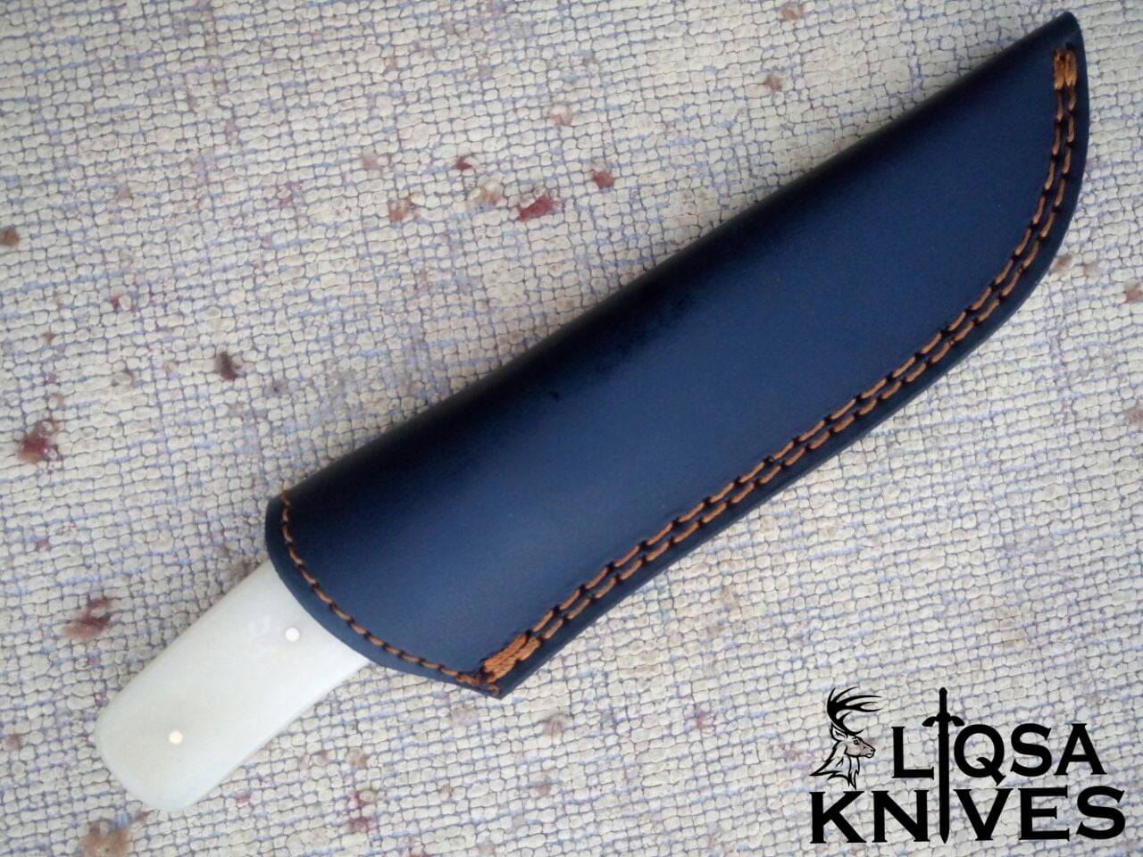 Bone Handle Damascus Knife is in its handmade leather sheath, designed for easy belt attachment and secure storage.