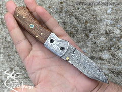A person using a custom Damascus folding knife to perform a task, highlighting its functionality.